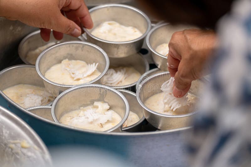 Группа в составе женщины положила мясо кокоса к десерту традиционного банана кухни кислому стоковые фото