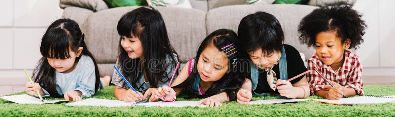 Группа в составе 5 мульти-этнических молодых милых preschool детей, мальчик и исследование или чертеж совместно дома или школа де стоковое фото rf