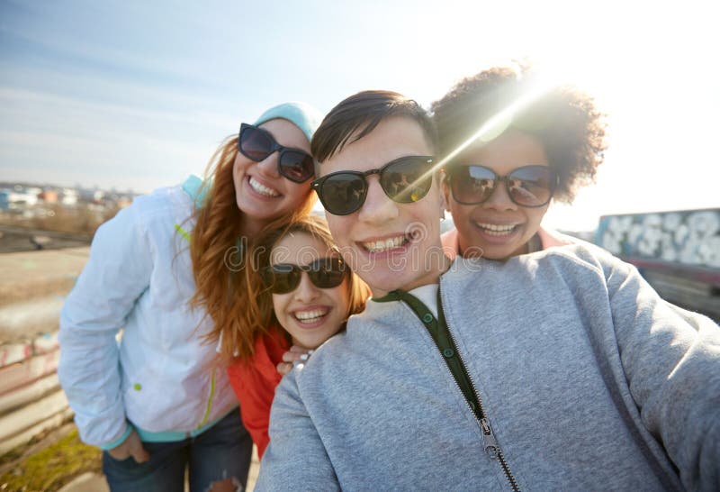 Группа в составе счастливые друзья принимая selfie на улице стоковые изображения rf Группа в составе счастливые друзья принимая selfie на улице стоковые изображения rf