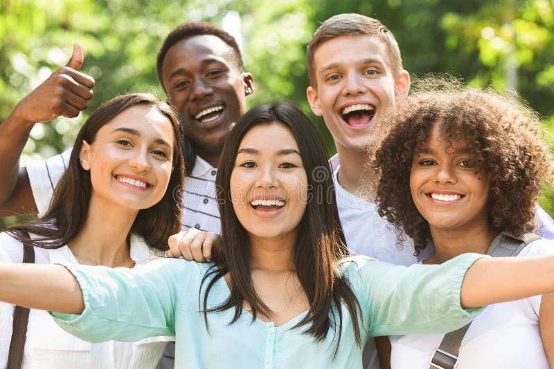 Группа многонациональные teen друзья, фотографируя selfie на открытом воздухе стоковая фотография rf