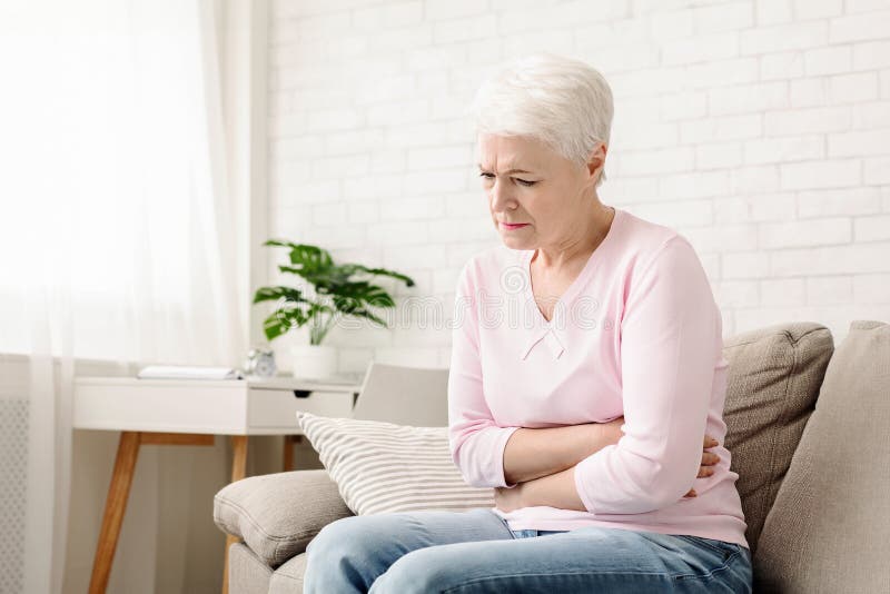 Age disruption of gastrointestinal tract work. Sad senior woman holding her abdomen, suffering from stomach problems, free space. Age disruption of gastrointestinal tract work. Sad senior woman holding her abdomen, suffering from stomach problems, free space