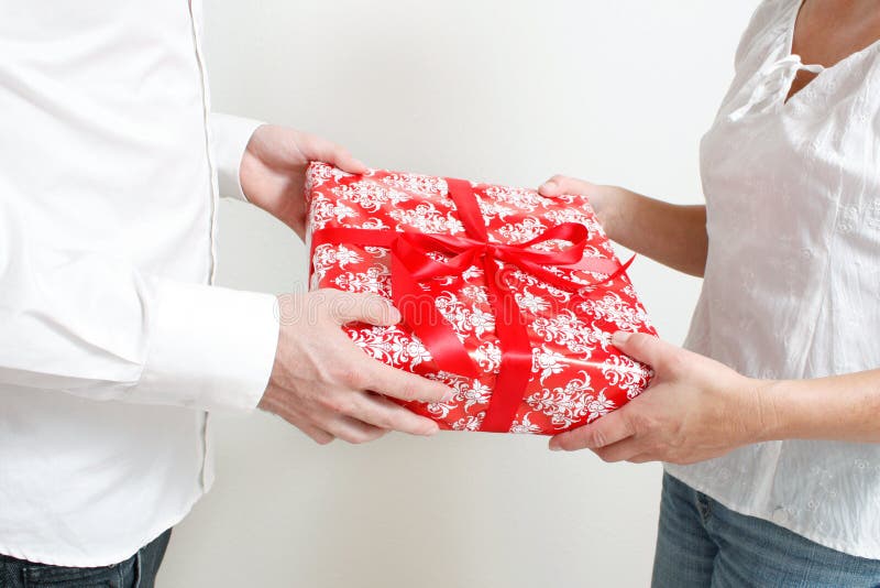 A man giving a christmas present to a woman. A man giving a christmas present to a woman