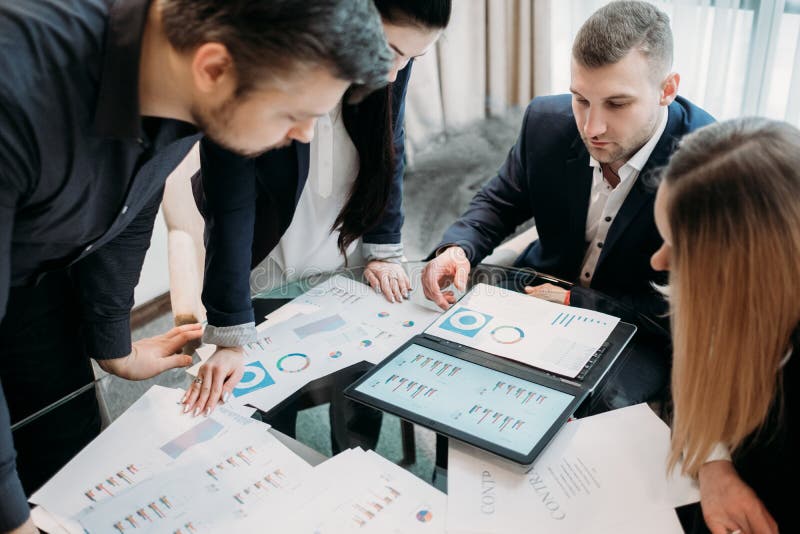 Office meeting. business team brainstorming. group of workers study documents with graphs and diagrams. information analysis. Office meeting. business team brainstorming. group of workers study documents with graphs and diagrams. information analysis
