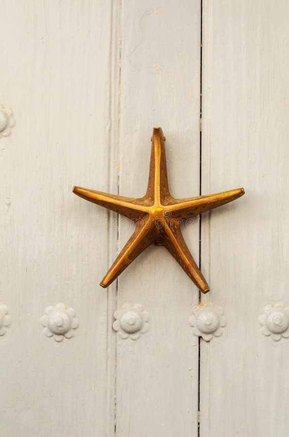 Дверь с латунным knocker в форме морской звёзды, красивым en стоковая фотография Дверь с латунным knocker в форме морской звёзды, красивым en стоковая фотография