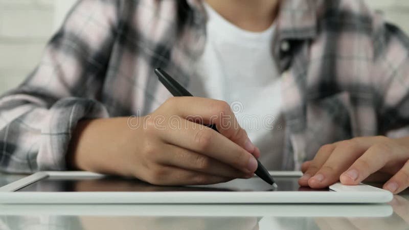 девочка пишет на планшетном ребёнке, записывает домашнее задание для школьного ребенка, который учится на дому, обучаясь онлайн-об видеоматериал
