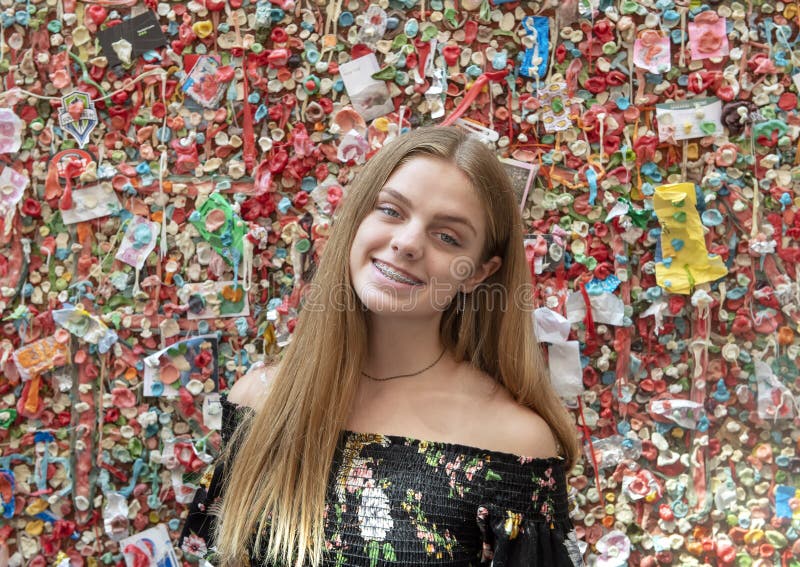 Pictured is a fourteen year-old teenage girl in front of a section of the Market Theater Gum Wall in an alleyway in Post Alley under Pike Place Market in Downtown Seattle. Market officials deemed the gum wall a tourist attraction. Parts of the wall are covered, 15 feet high for 50 feet. The girls are on a family vacation. Pictured is a fourteen year-old teenage girl in front of a section of the Market Theater Gum Wall in an alleyway in Post Alley under Pike Place Market in Downtown Seattle. Market officials deemed the gum wall a tourist attraction. Parts of the wall are covered, 15 feet high for 50 feet. The girls are on a family vacation