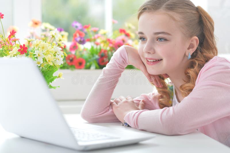 девочка-подросток сидит за столом с ноутбуком Стоковое Изображение ...