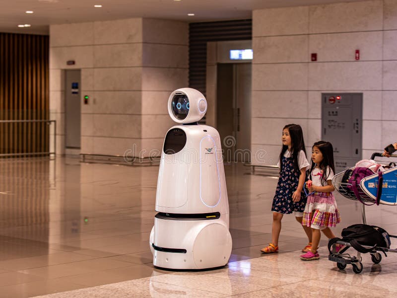 Incheon  South Korea - 14 September 2019: Two little girl follow AIRSTAR - a passenger aiding robot at Incheon International Airport. Incheon  South Korea - 14 September 2019: Two little girl follow AIRSTAR - a passenger aiding robot at Incheon International Airport