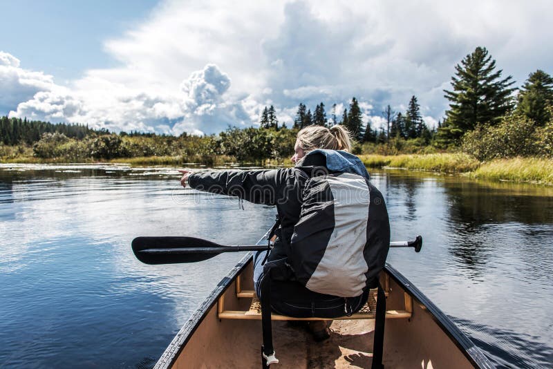 Девушка canoeing с каное на озере 2 рек в национальном парке algonquin в Онтарио Канаде на солнечный пасмурный день