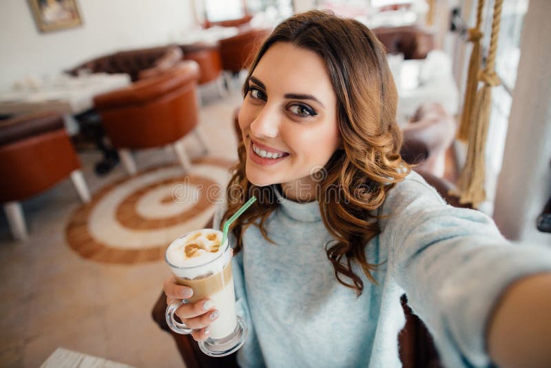 Девушка Oung делая автопортрет с coffe в кафе стоковые фото Девушка Oung делая автопортрет с coffe в кафе стоковые фото