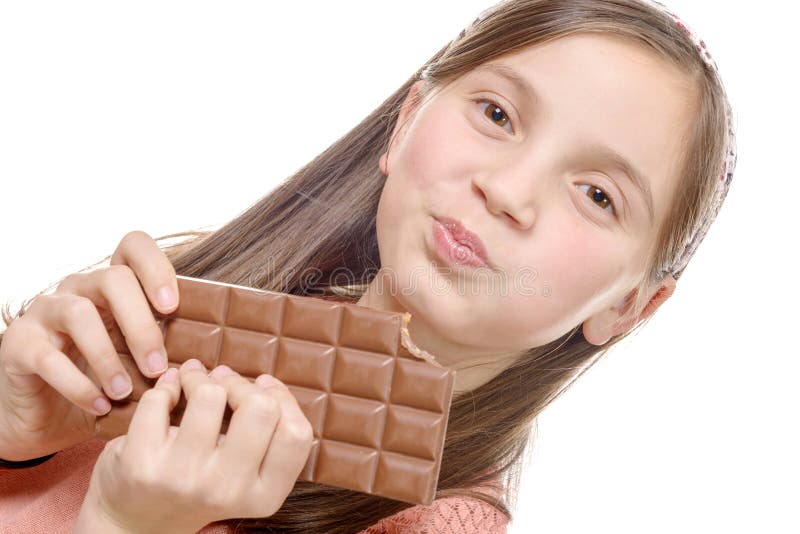 Девушка Preteen ест шоколад, изолированный на белизне стоковые изображения rf Девушка Preteen ест шоколад, изолированный на белизне стоковые изображения rf