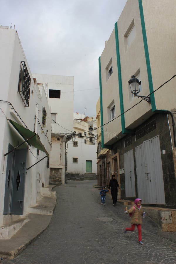 Девушка бежать в улице в Tetouan, городе в Марокко/Северной Африке, строя заходом солнца стоковое изображение rf Девушка бежать в улице в Tetouan, городе в Марокко/Северной Африке, строя заходом солнца стоковое изображение rf