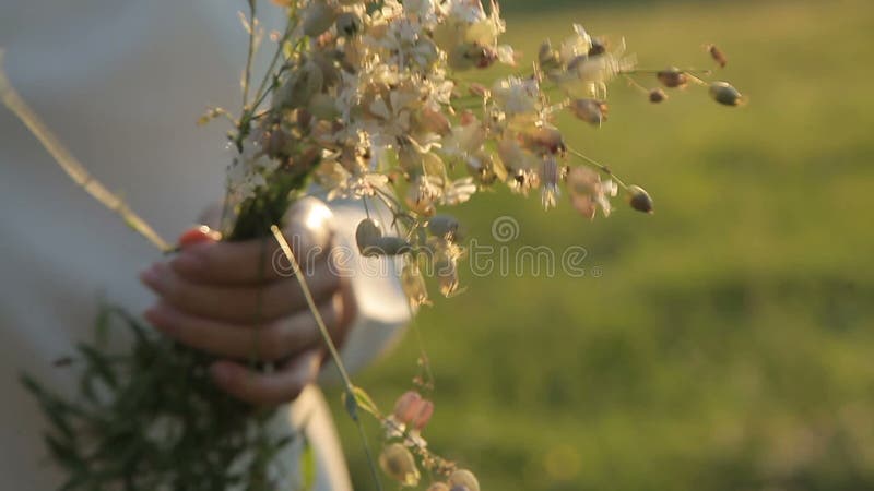 Девушка держа полевые цветки в руках