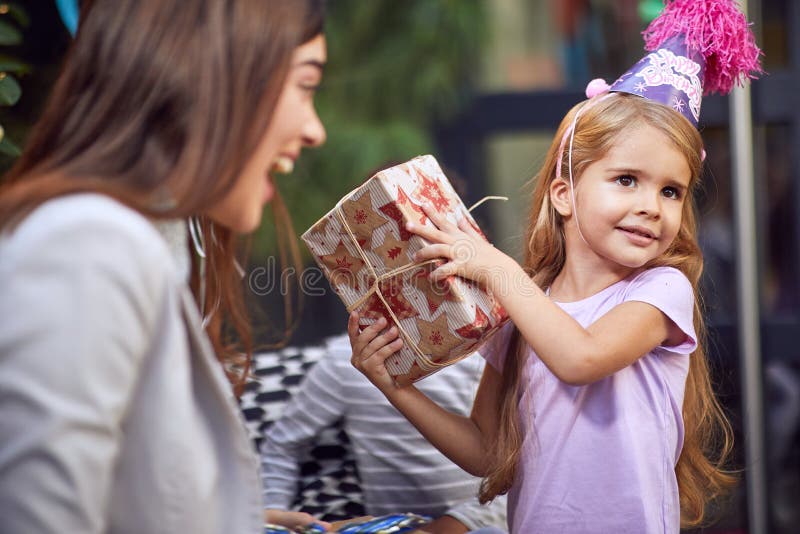 Девушка дня рождения и ее партия дня рождения открытия девушки presentschild giftbirthday дома стоковые изображения rf