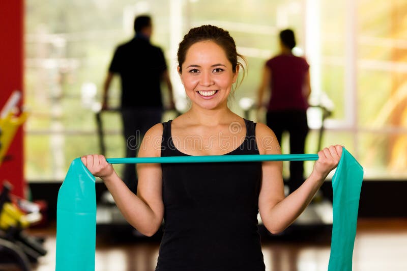 Girl using a resistance band in her exercise routine. Woman fitness elastic excercises. Girl using a resistance band in her exercise routine. Woman fitness elastic excercises.