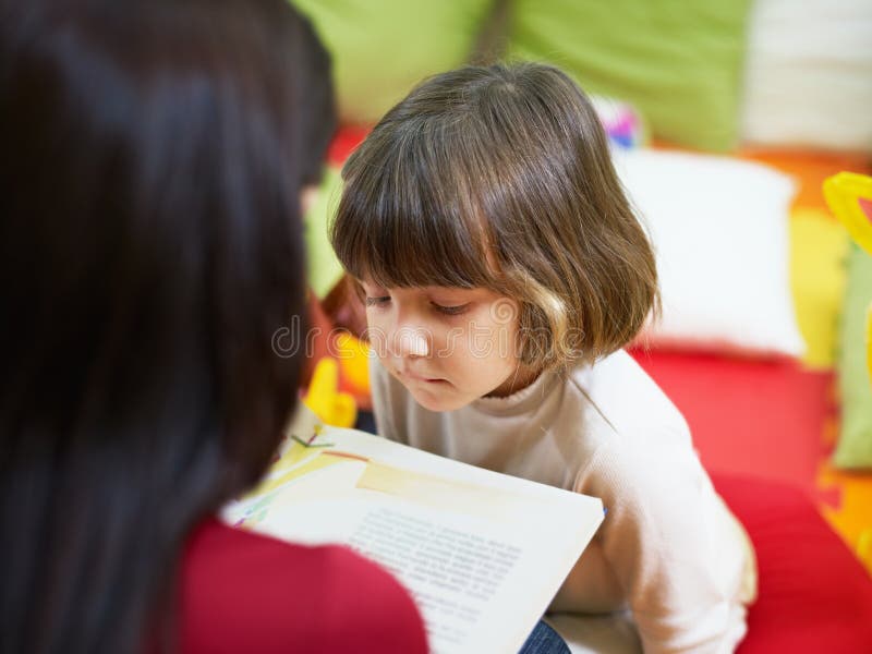 2-3 years girl listening to fairy tale in kindergarten. Horizontal shape. 2-3 years girl listening to fairy tale in kindergarten. Horizontal shape