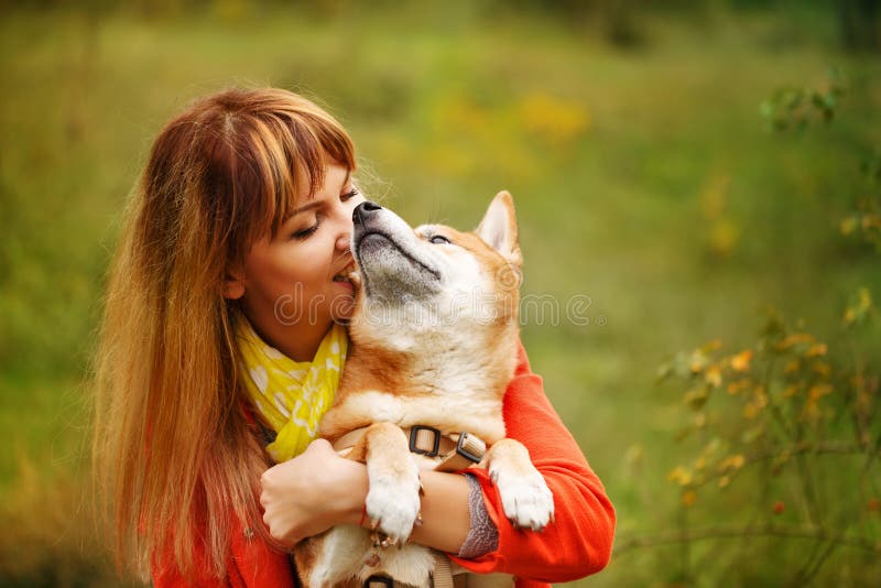 Девушка обнимая собаку Shiba Inu в парке осени стоковые фото Девушка обнимая собаку Shiba Inu в парке осени стоковые фото