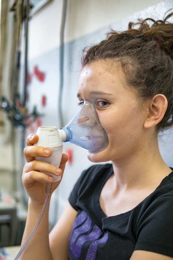 Девушка подростка делая вдыхание с nebulizer в больнице стоковые изображения Девушка подростка делая вдыхание с nebulizer в больнице стоковые изображения
