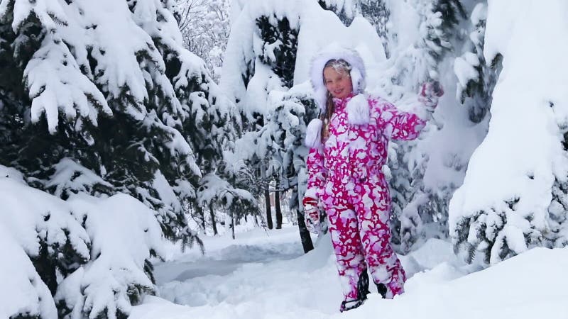 Девушка ребенка в зимнее время, играя в снегу в парке на открытом воздухе. акции видеоматериалы