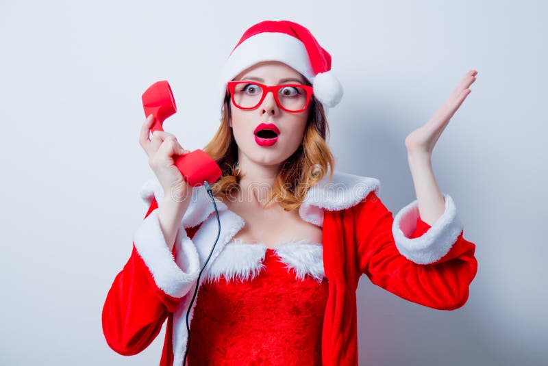 Девушка Санты Clous с eyeglasses и телефонной трубкой стоковое фото rf Девушка Санты Clous с eyeglasses и телефонной трубкой стоковое фото rf