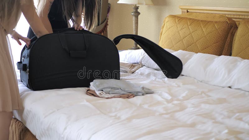 Девушки открыть чемодан в гостиничном номере