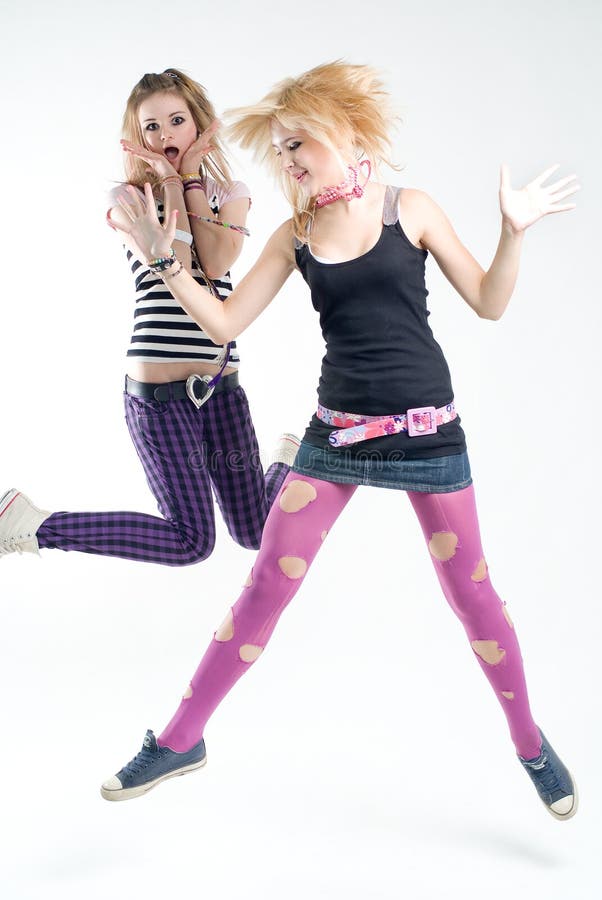 Two expressive jumping punk girls studio shot. Two expressive jumping punk girls studio shot