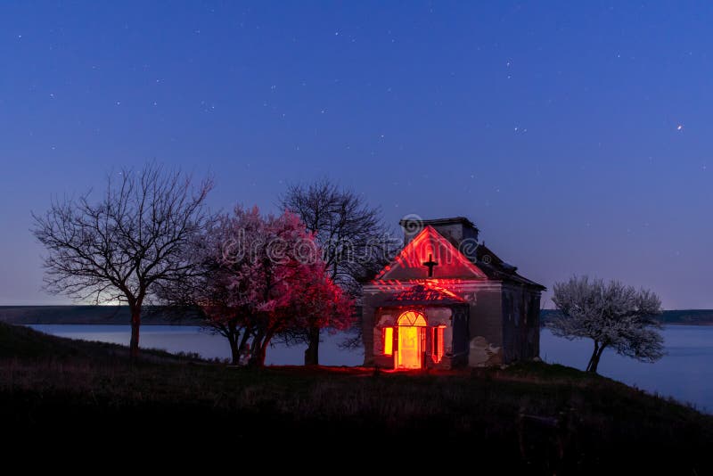Дезертированная церковь и зацветая nightscape деревьев стоковая фотография rf Дезертированная церковь и зацветая nightscape деревьев стоковая фотография rf