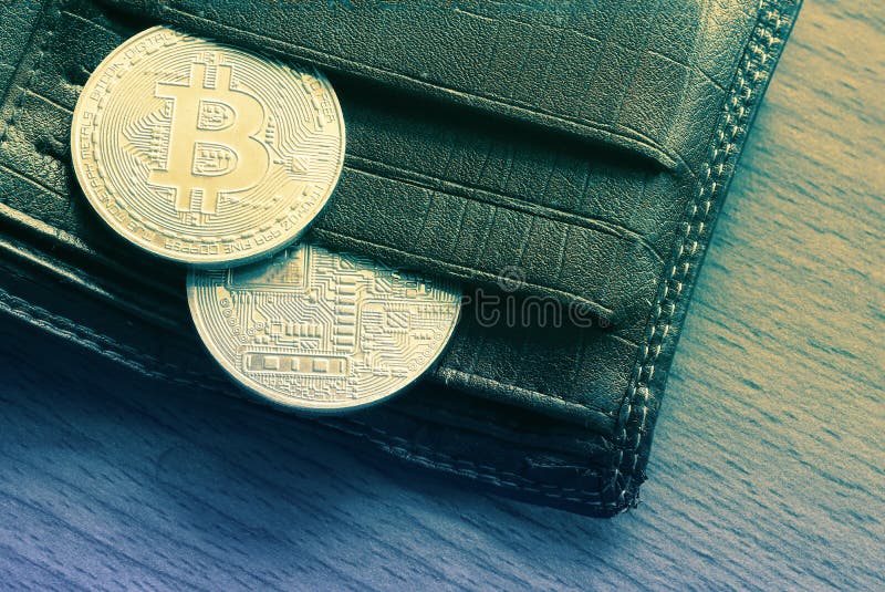 Деньги золотой монетки Bitcoin виртуальные в бумажнике на деревянном стоковое фото rf Деньги золотой монетки Bitcoin виртуальные в бумажнике на деревянном стоковое фото rf