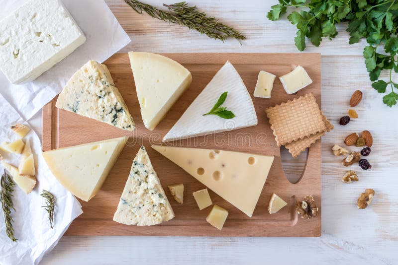 Деревянная доска с различными видами очень вкусного сыра с гайками стоковое фото Деревянная доска с различными видами очень вкусного сыра с гайками стоковое фото