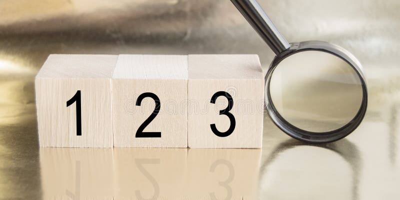 Wooden cubes with numbers 1,2,3 and magnifying glass on golden background with reflection, BASIC BUSINESS concept. Wooden cubes with numbers 1,2,3 and magnifying glass on golden background with reflection, BASIC BUSINESS concept.