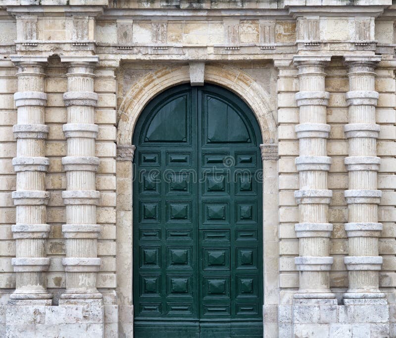 Detail of an old urban building stone facade with tall green wood door and decorative columns, Valletta, Malta. Detail of an old urban building stone facade with tall green wood door and decorative columns, Valletta, Malta