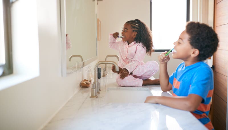 Two Children Brushing Their Teeth In Bathroom At Home. Two Children Brushing Their Teeth In Bathroom At Home