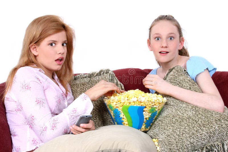 Two fourteen year old girls on the couch watching tv with surprised expression. Shot with the Canon 20D. Two fourteen year old girls on the couch watching tv with surprised expression. Shot with the Canon 20D.