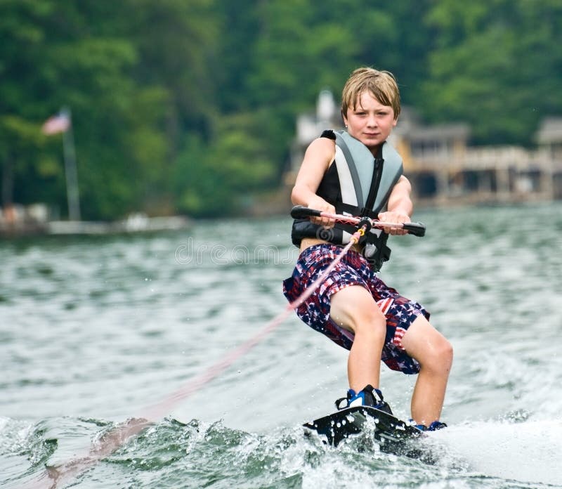 детеныши мальчика wakeboarding стоковые изображения rf детеныши мальчика wakeboarding стоковые изображения rf