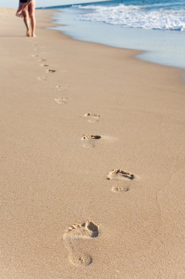 Young girl walk in the beach and their footprints in the sand. Young girl walk in the beach and their footprints in the sand