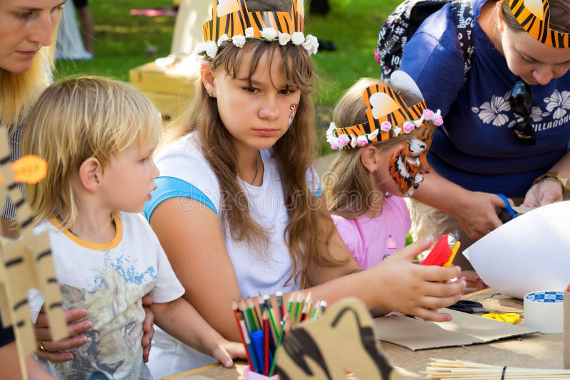 Moscow, Russia - July 31, 2016: children in tiger costumes draw and create crafts during the celebration of the international tiger day in Moscow. Moscow, Russia - July 31, 2016: children in tiger costumes draw and create crafts during the celebration of the international tiger day in Moscow.