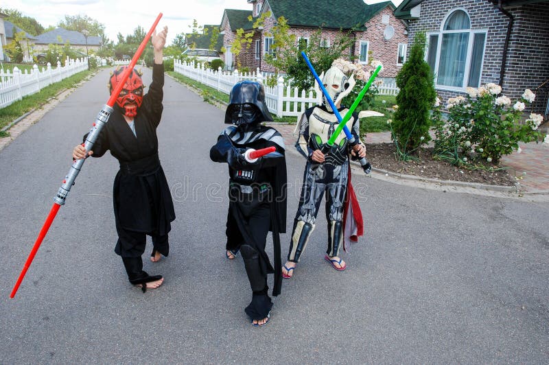 Дети замаскированные в костюмах Звездных войн: Дротик избивает, Darth Vader со шпагами Darth Vader стоковые изображения rf Дети замаскированные в костюмах Звездных войн: Дротик избивает, Darth Vader со шпагами Darth Vader стоковые изображения rf