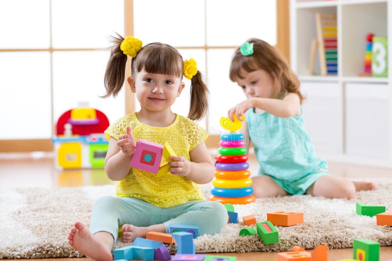 Дети играя с блоками совместно Воспитательные игрушки для preschool и ребенка детского сада Игрушки строения маленьких девочек на стоковые изображения