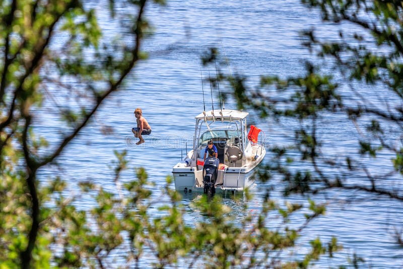 Дети ныряют в морскую воду от моторки побережьем Чёрного моря гор Cuacasus стоковые фото