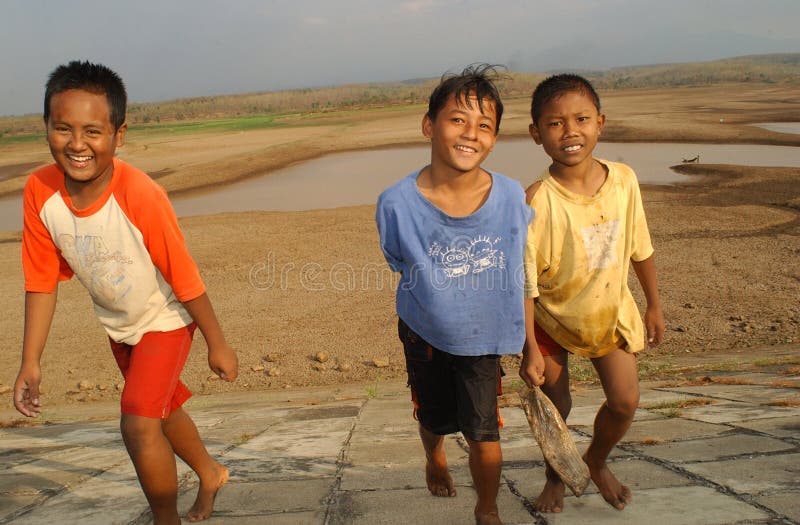 Дети около резервуара хранения Dawuhan, Wonoasri, Madiun стоковая фотография Дети около резервуара хранения Dawuhan, Wonoasri, Madiun стоковая фотография