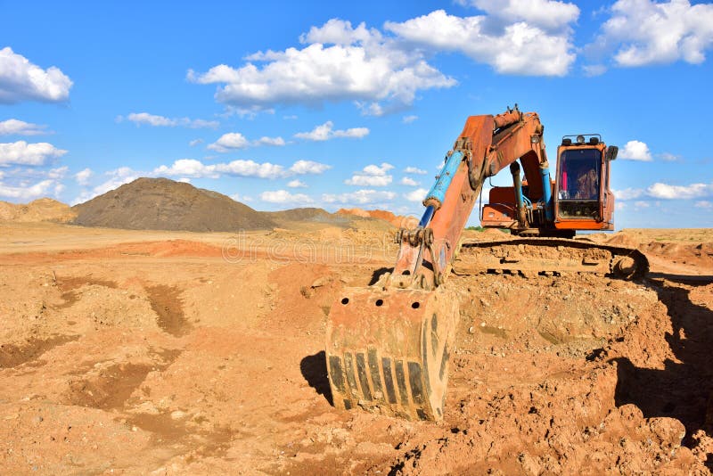 Деятельность экскаватора на earthmoving на добычу открытого карьера на фоне голубого неба. Экскаватор выкапывает песка в карьере. стоковое изображение rf