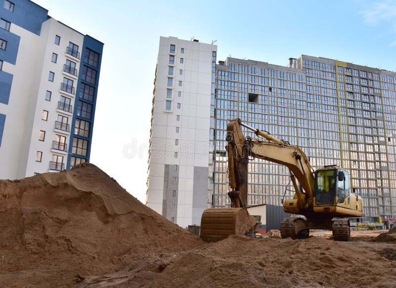 Деятельность экскаватора на стройке. Экскаватор на дорожной работе и earthworks. Earthmoving тяжелое оборудование для строительств стоковое фото