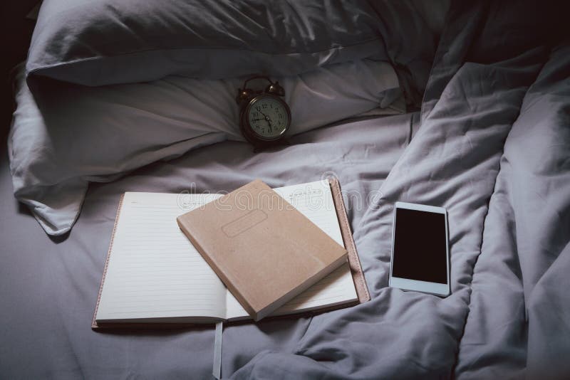 дневник и планировщик. книга смартфона с записной книжкой и часами, размещенными на одеяле. образ жизни студента стоковые изображения