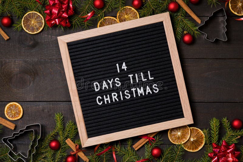 Fourteen Days till Christmas countdown felt letter board flatlay on dark rustic wood table with Christmas decoration and fir tree boarder. Fourteen Days till Christmas countdown felt letter board flatlay on dark rustic wood table with Christmas decoration and fir tree boarder
