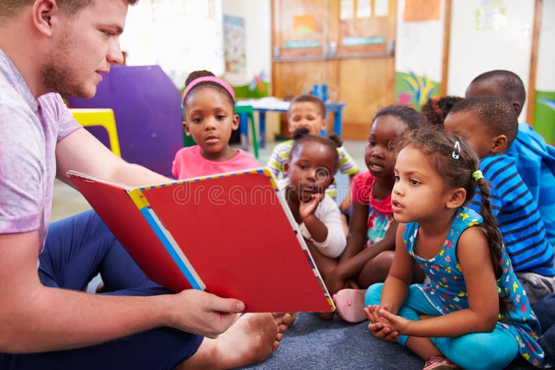 Добровольный учитель читая к классу preschool ягнится стоковое изображение Добровольный учитель читая к классу preschool ягнится стоковое изображение