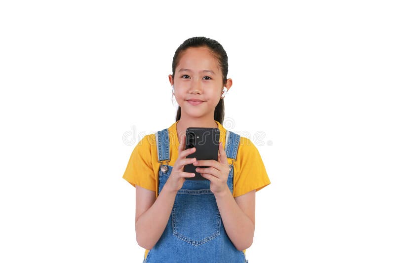 Довольно азиатская девушка наслаждается прослушиванием музыки с помощью смартфона и беспроводных наушников, изолированных на белом стоковые фото