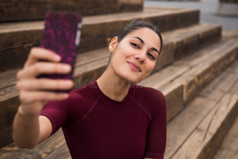 Довольно молодая sporty женщина принимая selfie стоковое изображение rf Довольно молодая sporty женщина принимая selfie стоковое изображение rf