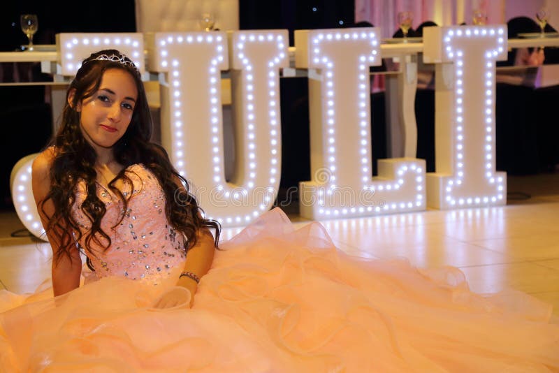 Довольно предназначенная для подростков девушка дня рождения quinceanera празднуя в партии пинка платья принцессы, специальном то стоковое фото