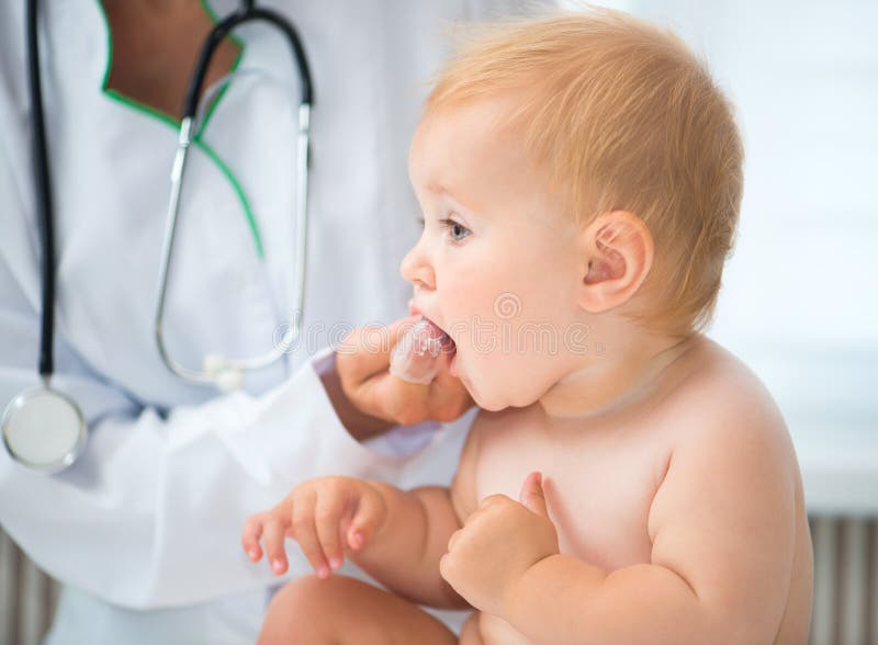 Doctor cleans baby teeth with a special brush. Doctor cleans baby teeth with a special brush