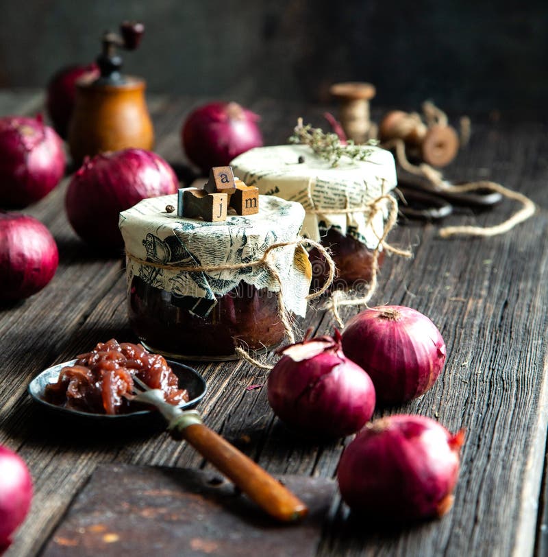 Домашняя вкусная консервированная луковая красная джема, мармелад, конфетка, чатни в двух стеклянных барах на заросшем деревянном стоковое изображение Домашняя вкусная консервированная луковая красная джема, мармелад, конфетка, чатни в двух стеклянных барах на заросшем деревянном стоковое изображение